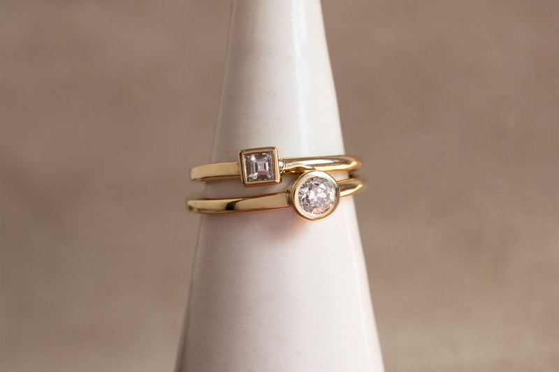 A closeup view of the Carré square cut and round old European yellow gold Ageku rings